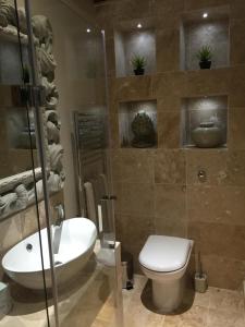 a bathroom with a toilet and a sink at Hill Farm Bed and Breakfast in Little Massingham