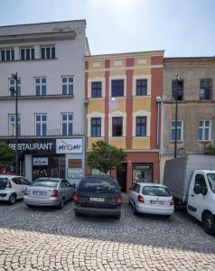 grupa samochodów zaparkowanych przed budynkami w obiekcie Apartmán Dolní náměstí w Ołomuńcu