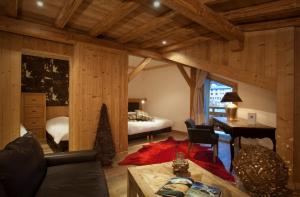 a bedroom with a bed and a desk in a room at Hotel Les Mélèzes in Les Deux Alpes