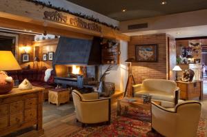 a living room with a fireplace and a couch at Hotel Les Mélèzes in Les Deux Alpes