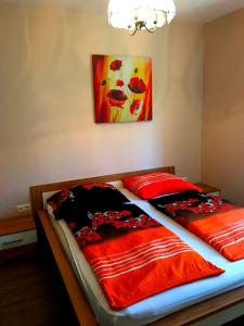 シオーフォクにあるPrincess Luxus Apartmanのベッドルーム1室(赤い毛布と絵画が備わるベッド2台付)
