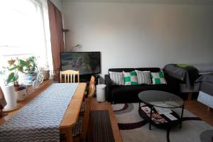 a living room with a black couch and a table at Cozy Apartment near Turku Cathedral Church in Turku