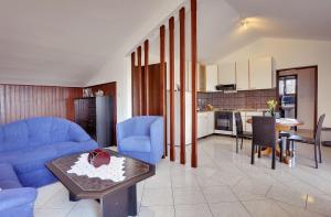 salon z niebieską kanapą i stołem w obiekcie Holiday Home Lorena w mieście Premantura