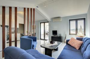 salon z niebieską kanapą i stołem w obiekcie Holiday Home Lorena w mieście Premantura