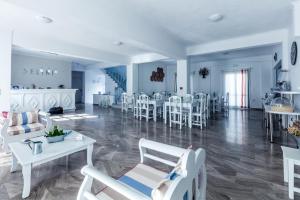 a living room with white chairs and a dining room at Selini Ηotel in Kamari