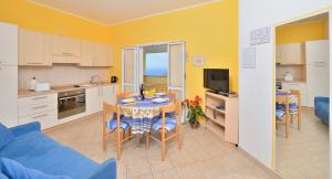a kitchen and living room with a table and a blue couch at Residence Elvira in Diano Marina