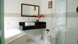 a bathroom with a sink and a toilet and a mirror at Pousada Sonho Meu in Paraty +136 photos