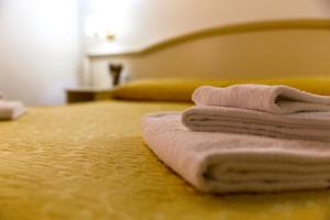 une pile de serviettes assises au-dessus d'un lit dans l'établissement Best Suites Pantheon, à Rome