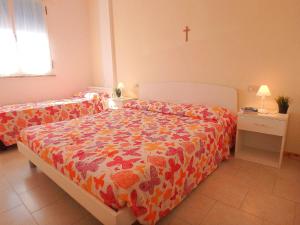 1 dormitorio con 1 cama y 1 cruz en la pared en Montebianco 30 en Lido di Pomposa
