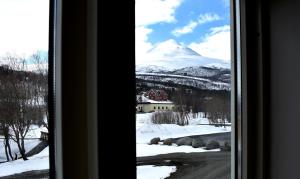 a view of a snow covered mountain from a window at Lyngseidet Gjestegård in Lyngseidet