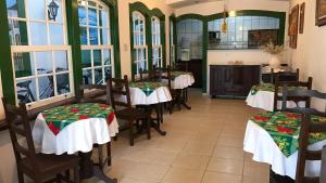 a restaurant with tables and chairs in a room with windows at Pousada Sonho Meu in Paraty