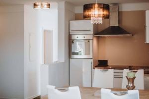 ヴィリンゲンにあるXenos Apartmentのキッチン(白い家電製品、テーブル、白い椅子付)