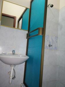 uma casa de banho com um lavatório e um chuveiro com um espelho. em Hotel Boston em Guayaquil