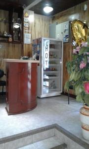 eine Küche mit einem Kühlschrank, einem Tisch und einer Pflanze in der Unterkunft Hotel Boston in Guayaquil