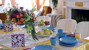 un tavolo con piatti blu e ciotole di frutta e fiori di La Locanda Francigena a Lucca