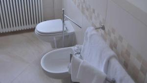 Un baño con inodoro y lavabo con toallas. en La Locanda Francigena, en Lucca
