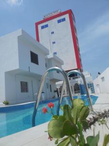 uma piscina em frente a um edifício com um edifício em Hotel BKBG em Lomé