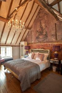 a bedroom with a large bed and a chandelier at The Broad Leys in Aylesbury