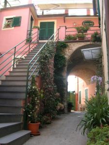 una escalera que conduce a un edificio rosa con plantas en L'Antica Pieve Bed & Breakfast, en Levanto