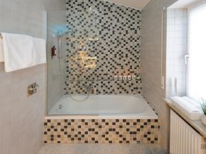bagno con vasca e doccia in vetro di Donau Lodge Boardinghouse a Straubing Altre 79 foto