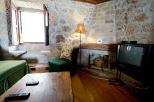 a living room with a tv and a fireplace at Solar Olivas Apartments in Carvalhal