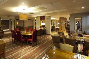 a living room filled with tables and chairs at Premier Inn London Heathrow Airport T2 & T3 - Bath Road in Hillingdon