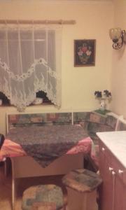 Nagyvisnyó的住宿－貝克茨公寓，一间设有一张桌子、两张凳子和窗户的房间