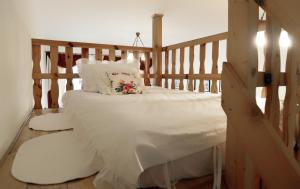 1 dormitorio con cama de madera con sábanas y almohadas blancas en Pokoje Gościnne Victoria, en Cracovia