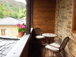 a balcony with two chairs and a table and a window at Apartamento El Valle de Oscos in Santa Eulalia de Oscos