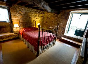 um quarto com uma cama num quarto com paredes de pedra em Solar Olivas Apartments em Carvalhal
