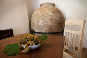 un tazón de uvas sobre una mesa con un jarrón grande en L'Antica Pieve Bed & Breakfast, en Levanto