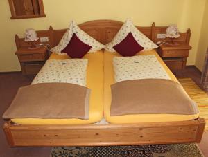 a wooden bed with two pillows on it at Hotel Adlerschanze in Schönwald