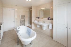 カウズにあるCliffhanger 18 Castle Roadの浴槽と洗面台を備えた広いバスルーム
