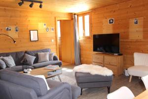 ein Wohnzimmer mit Sofas und einem Flachbild-TV in der Unterkunft La Boutique in Rossinière