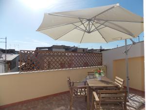 a patio with a table and an umbrella on a roof at Residence Ideal in Alcamo