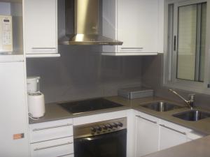 a kitchen with white cabinets and a stove and a sink at Saromar II Apartament amb dues terrasses per 6 persones a 5 minuts de la Platja Gran in Platja  d'Aro +33 photos
