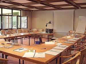 ein großes Zimmer mit Tischen und Stühlen in einem Klassenzimmer in der Unterkunft Landhotel Niederthäler Hof in Schloßböckelheim