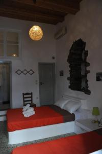 a bedroom with a bed with a red blanket at Apano Vrysi in Tinos