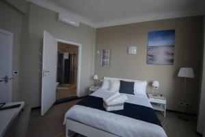 a bedroom with a large bed and a bathroom at Luna Rooms in Savona