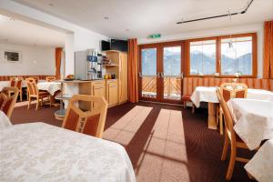 a dining room with tables and chairs and a kitchen at Haus Brigitte in Serfaus
