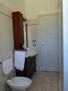 baño con aseo, lavabo y puerta en Casa Sole e Vento, en Birgi Vecchi