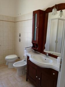 a bathroom with a sink and a toilet and a mirror at Casa Sole e Vento in Birgi Vecchi +16 photos