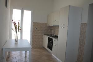 a kitchen with a table and a white refrigerator at Casa Sole e Vento in Birgi Vecchi