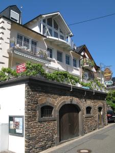 ein Backsteingebäude mit Balkon darüber in der Unterkunft Ferienwohnung Schneemann in Valwig