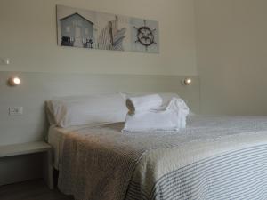 Una cama blanca con una almohada blanca encima. en Hotel ai Fiori, en Grado
