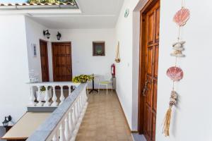 una escalera en una casa con paredes blancas y una puerta de madera en AKANTHUS STUDIOS - Ex Vergos Pavlos, en Parga