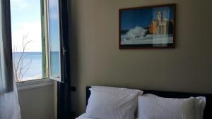 a bedroom with a bed with a picture on the wall at Luna Rooms in Savona