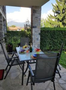 stół i 2 krzesła na patio w obiekcie Casa Lella with pool and garden w mieście Lenno