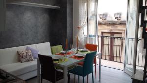 een eetkamer met een tafel en stoelen bij Taormina Rainbow House in Taormina