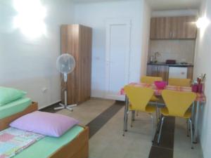 a room with a table and chairs and a kitchen at Apartmani Lav in Sutomore